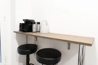 a counter with two stools under a table with a coffee maker at GuestReady - Spacious City Haven in Valencia in Valencia