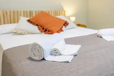 a white bed with towels and blankets on it at Carmen Beach Hostel Cullera in Cullera
