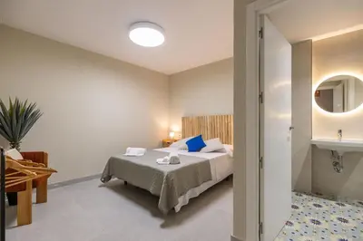 a hotel room with a bed and a mirror at Carmen Beach Hostel Cullera in Cullera