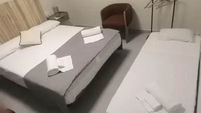 a room with two beds and a chair in it at Carmen Beach Hostel Cullera in Cullera