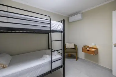 a bunk bed room with two bunk beds and a chair at Carmen Beach Hostel Cullera in Cullera