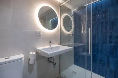 a bathroom with a sink and a shower at Carmen Beach Hostel Cullera in Cullera