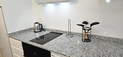a kitchen with a granite counter top with utensils at Vacansis Valencia Bajo Torrefiel in Valencia