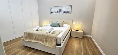 a bedroom with a large white bed and two lamps at Vacansis Valencia Bajo Torrefiel in Valencia