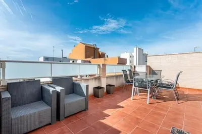 a balcony with a table and chairs on a roof at Acogedor y excelente ubicación in Puerto de Sagunto