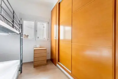 a bedroom with a bunk bed and a wooden closet at Acogedor y excelente ubicación in Puerto de Sagunto