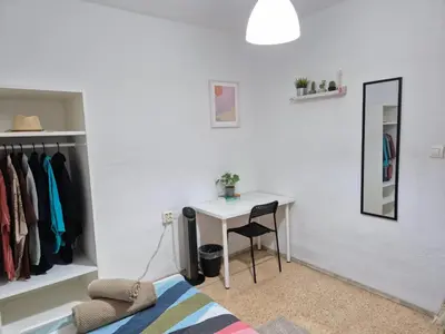 a bedroom with a desk and a bed and a mirror at All you need in Valencia