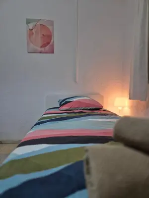 a bed with a colorful striped blanket in a bedroom at All you need in Valencia