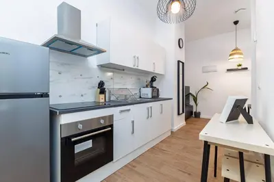 a kitchen with white cabinets and a stove top oven at Quiet & Modern Apartment in Valencia