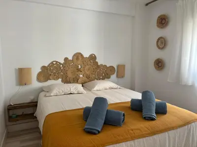 a bedroom with a bed with two blue pillows on it at Faro Cullera Sea view in Faro de Cullera