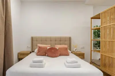 a bedroom with a large bed with white sheets and pillows at Bright & Modern Apartment - Rose y Maya in Valencia