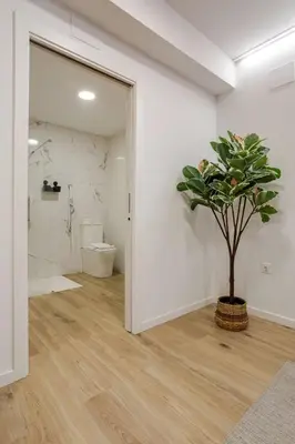 a bathroom with a toilet and a potted plant at Bright & Modern Apartment - Rose y Maya in Valencia