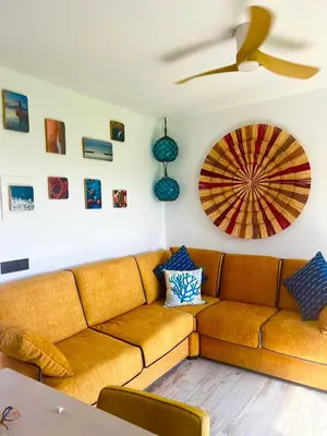 a living room with a brown couch and a ceiling at Barco - casa con jardín privado frente al mar in Mareny Barraquetas