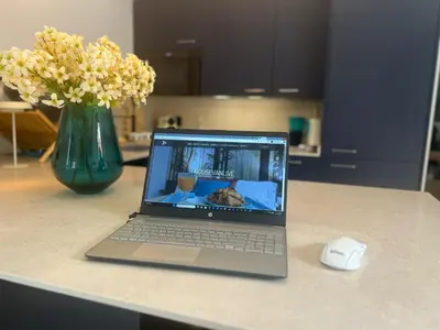 a laptop computer sitting on a counter with a vase of flowers at Barco - casa con jardín privado frente al mar in Mareny Barraquetas