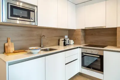 a kitchen with white cabinets and a sink and a microwave at Historic Center Apartment in Valencia
