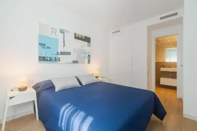 a bedroom with a blue bed and a white wall at Historic Center Apartment in Valencia