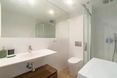 a white bathroom with a sink and a shower at Historic Center Apartment in Valencia