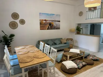 a living room with a table and chairs and a couch at Casa Playa El Perelló in El Perelló