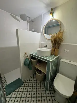 a bathroom with a sink and a toilet and a mirror at Casa Playa El Perelló in El Perelló
