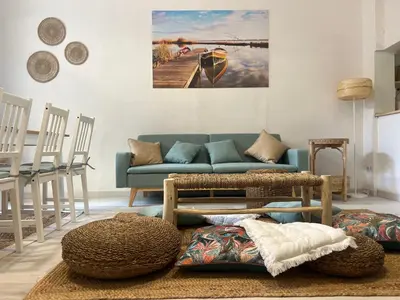 a living room with a blue couch and chairs at Casa Playa El Perelló in El Perelló