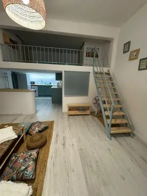a living room with a staircase and a couch at Casa Playa El Perelló in El Perelló