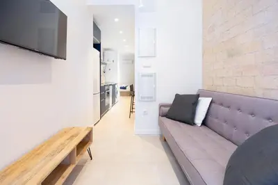 a living room with a couch and a table at My Loft 4 You Democracia I in Valencia
