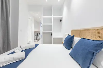a bedroom with a large white bed with blue pillows at My Loft 4 You Democracia I in Valencia