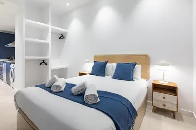 a bedroom with a large bed with blue pillows at My Loft 4 You Democracia I in Valencia