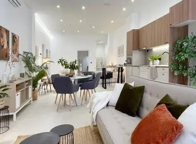 a living room and kitchen with a couch and a table at Sunny Stay Valencia 4 pax wifi in Valencia