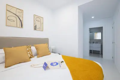 a bedroom with a white bed with yellow blankets and pillows at Dorm4You Calle Gibraltar 15 Ruzafa Apartments in Valencia