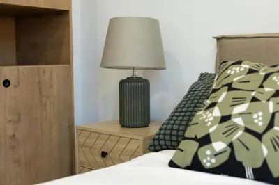 a lamp on a night stand next to a bed at Dorm4You Calle Gibraltar 15 Ruzafa Apartments in Valencia