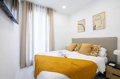 a bedroom with a large bed with a yellow blanket at Dorm4You Calle Gibraltar 15 Ruzafa Apartments in Valencia