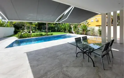 a patio with a glass table and chairs next to a swimming pool at Amazing Home In Serra in Serra