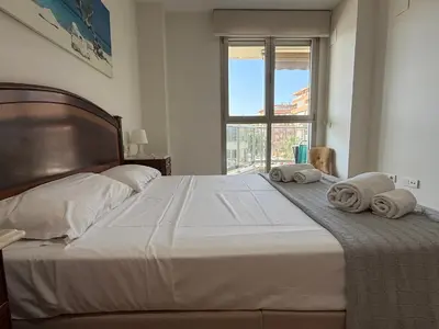 a bedroom with a large bed with towels on it at Reinapart Patacona Balcony Seaview in Valencia