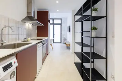 a kitchen with a black book shelf in the middle at My Loft 4 You Democracia II in Valencia
