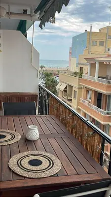 a wooden table on a balcony with a view of the ocean at District Key - Puerto de Sagunto, Virgen Losar in Puerto de Sagunto