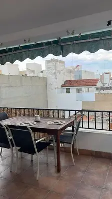 a wooden table and chairs on a balcony at District Key - Puerto de Sagunto, Virgen Losar in Puerto de Sagunto