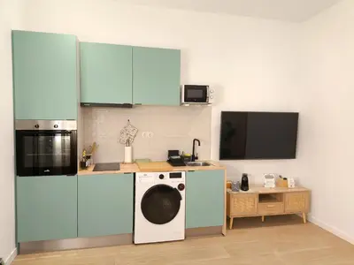a kitchen with a washing machine and a tv at The Sunshine Apartment in Valencia