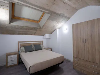 a bedroom with a bed and a wooden cabinet at Apartment San Pedro 4 in Valencia