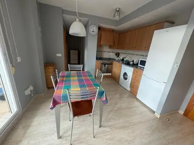 a kitchen with a table with chairs and a refrigerator at Raquel Host Moncofar in Moncófar