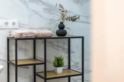 a black shelf with a plant on it in a bathroom at Estudio tranquilo cerca del Centro in Valencia