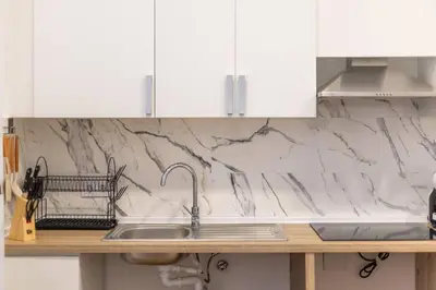 a kitchen counter with a sink and white cabinets at Estudio tranquilo cerca del Centro in Valencia