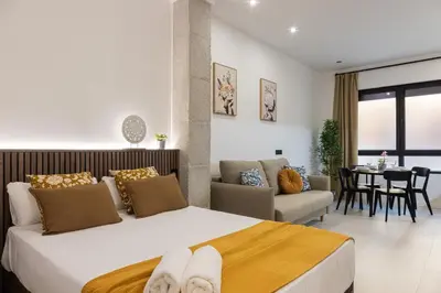 a bedroom with a large bed and a living room at FLORIT FLATS - The Maritim Studios in Valencia