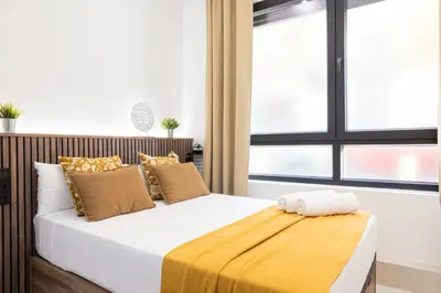 a bedroom with a bed with a yellow blanket on it at FLORIT FLATS - The Maritim Studios in Valencia
