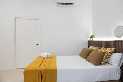 a bedroom with a bed with a yellow blanket on it at FLORIT FLATS - The Maritim Studios in Valencia