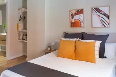 a bedroom with a bed with yellow pillows at VLC Host - Belgica Apartments in Valencia