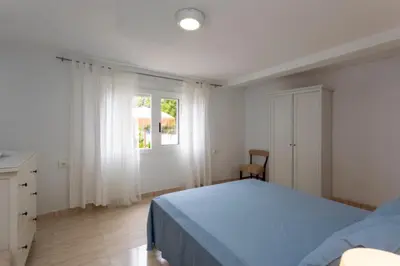 a white bedroom with a bed and a window at Casa La Mar in Mareny Blau