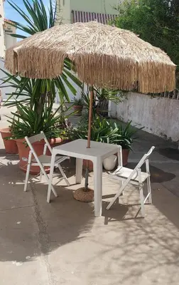 a table and two chairs under a straw umbrella at Casa La Mar in Mareny Blau