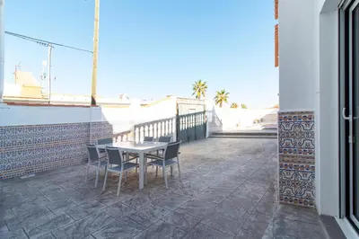 a patio with a table and chairs on a balcony at Global Vacacional, Deslumbrante casa en la playa de Sagunto in Sagunto