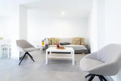 a living room with two chairs and a coffee table at Global Vacacional, Deslumbrante casa en la playa de Sagunto in Sagunto